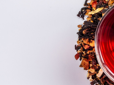 loose leaf tea around a cup of brewed loose leaf tea
