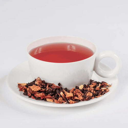 Crimson Punch tea in a cup with loose leaf tea in a saucer