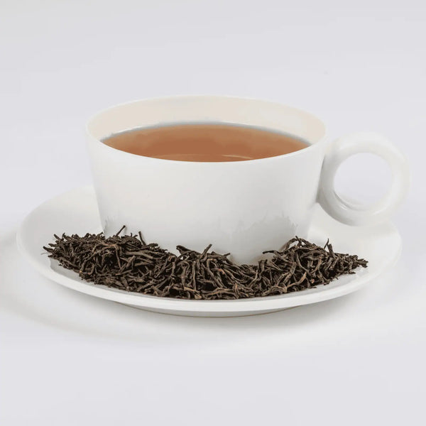 Earl Grey Reserve tea in a white teacup with loose leaf tea in a saucer