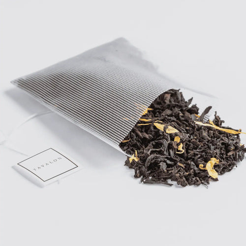 Peachy Oolong tea spilling out of a Soilon tea bag